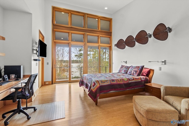 bedroom with access to exterior and light hardwood / wood-style flooring