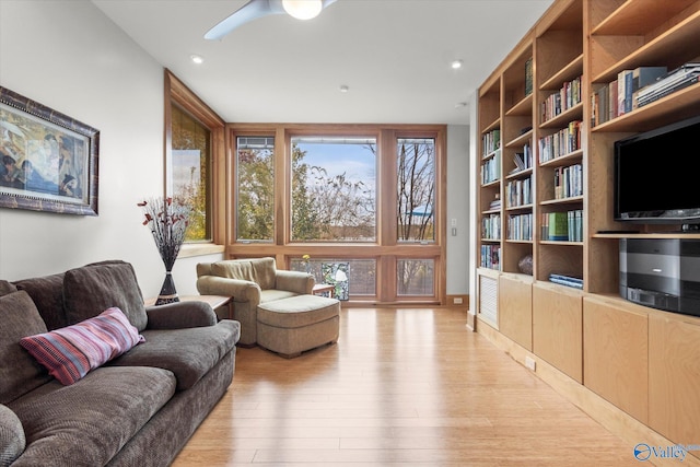 living room featuring light wood-type flooring and ceiling fan