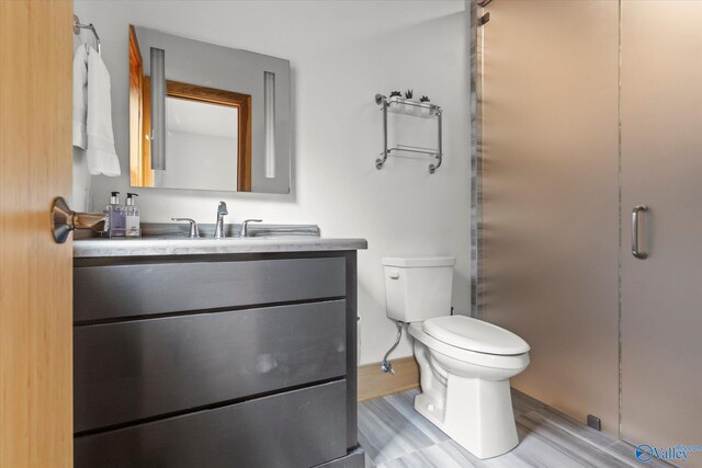 bathroom featuring hardwood / wood-style floors, vanity, and toilet