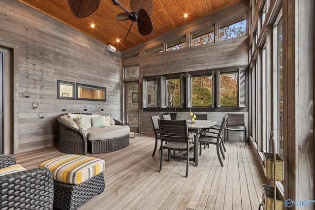 sunroom / solarium with ceiling fan, wooden ceiling, and lofted ceiling