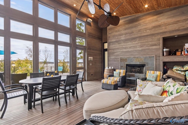 living room with light wood-type flooring, wood ceiling, ceiling fan, high vaulted ceiling, and a fireplace