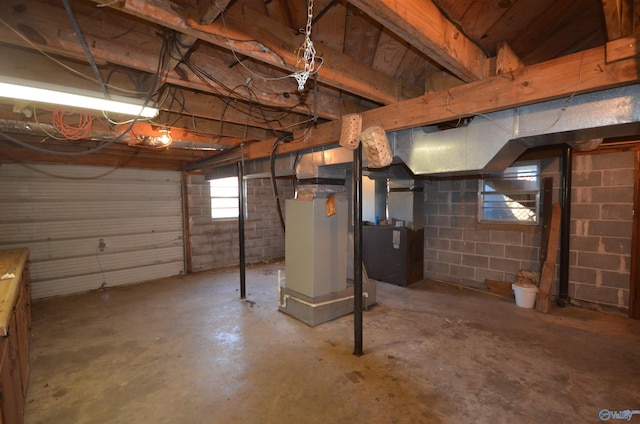 basement featuring heating unit and concrete block wall