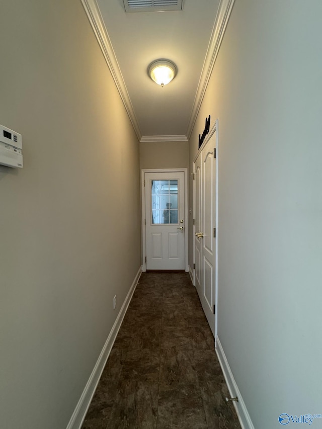 doorway featuring visible vents, baseboards, and crown molding