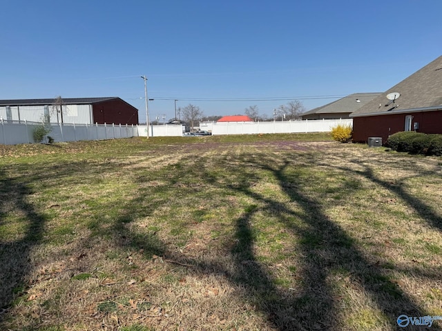 view of yard featuring central air condition unit and fence