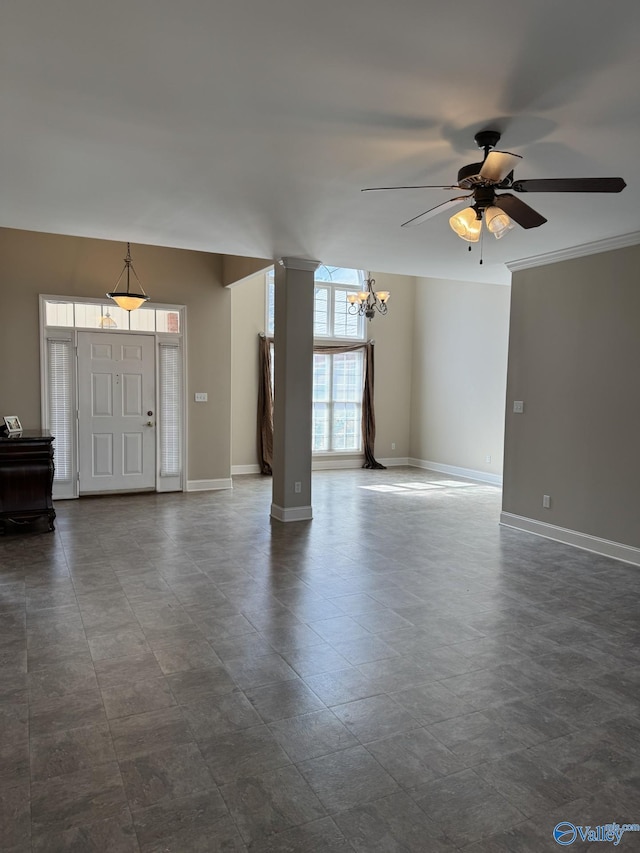 unfurnished living room featuring ceiling fan with notable chandelier and baseboards