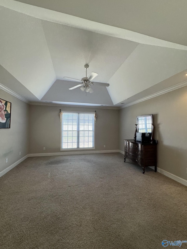 empty room with a ceiling fan, baseboards, carpet floors, lofted ceiling, and ornamental molding