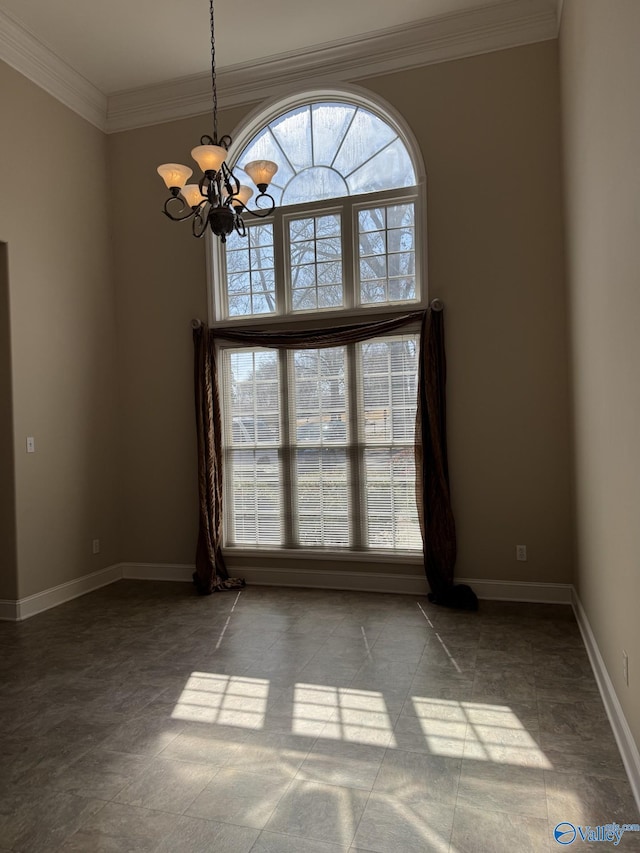 unfurnished room featuring crown molding, a notable chandelier, and baseboards