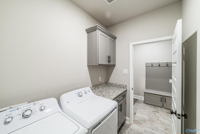 washroom with cabinets and washer and dryer