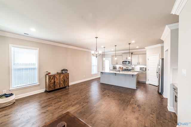 kitchen with white cabinets, dark hardwood / wood-style floors, an island with sink, decorative light fixtures, and stainless steel appliances