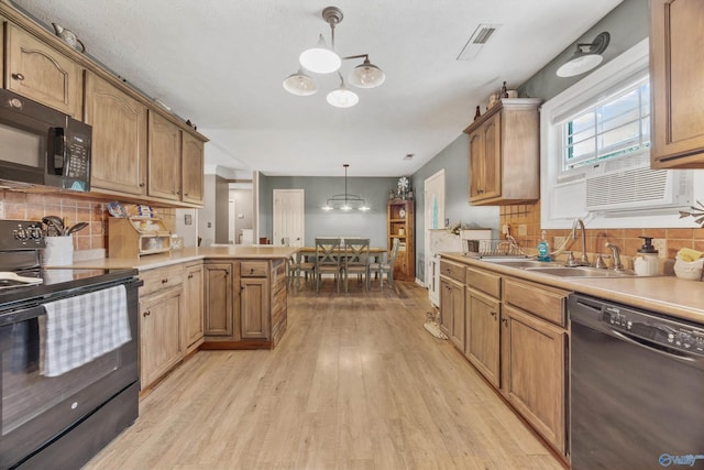 20729 Colonial Dr, Athens, AL 35614 - kitchen featuring black appliances, a chandelier, light wood finished floors, a peninsula, and backsplash