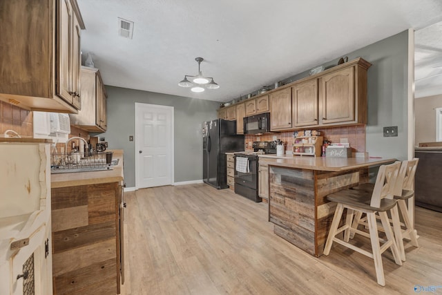 20729 Colonial Dr, Athens, AL 35614 - kitchen with black appliances, backsplash, light wood-style floors, light countertops, and a sink