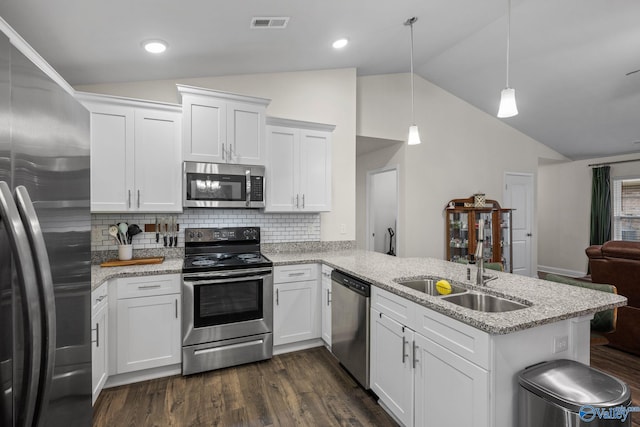 kitchen with decorative light fixtures, appliances with stainless steel finishes, kitchen peninsula, light stone countertops, and white cabinets