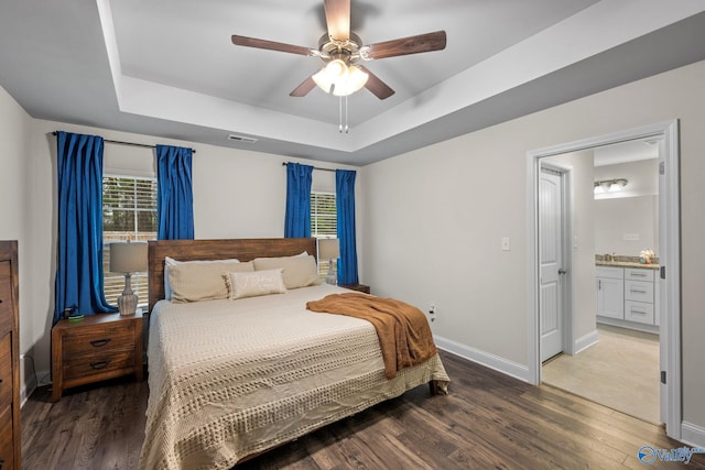 bedroom featuring ceiling fan, wood-type flooring, and a raised ceiling