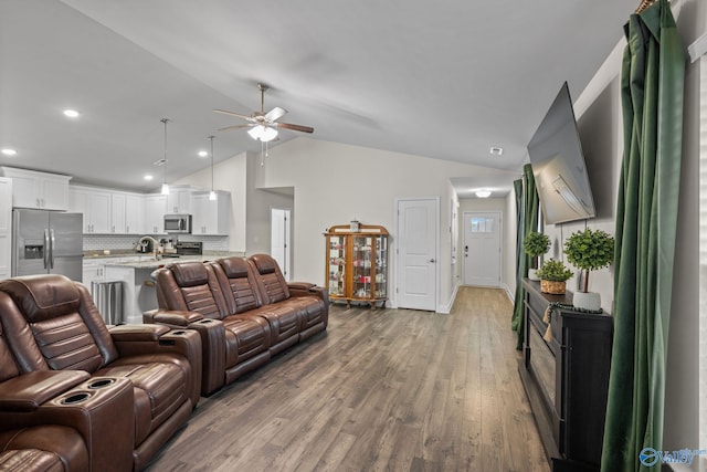 living room featuring hardwood / wood-style floors, vaulted ceiling, and ceiling fan