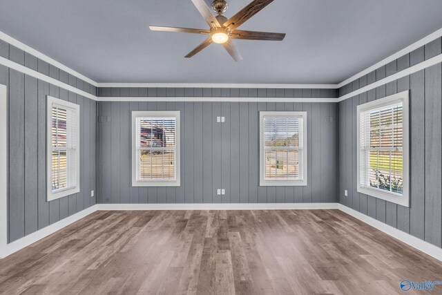 living room featuring dark wood-type flooring, a wall mounted AC, ceiling fan, and wood walls