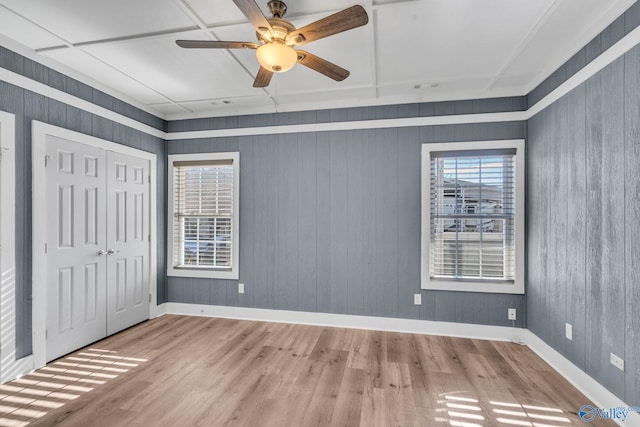 unfurnished bedroom with baseboards, a closet, a ceiling fan, and light wood-style floors