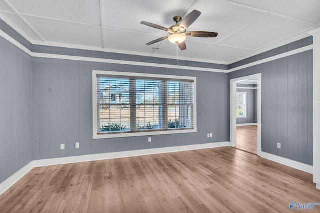 empty room featuring wood finished floors, a ceiling fan, and baseboards