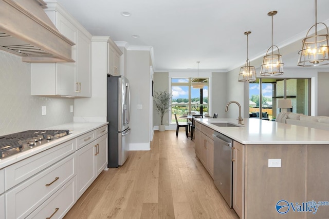 217 Idle Creek Dr, Huntsville, AL 35811 - kitchen with crown molding, light wood-style flooring, custom exhaust hood, a sink, and stainless steel appliances
