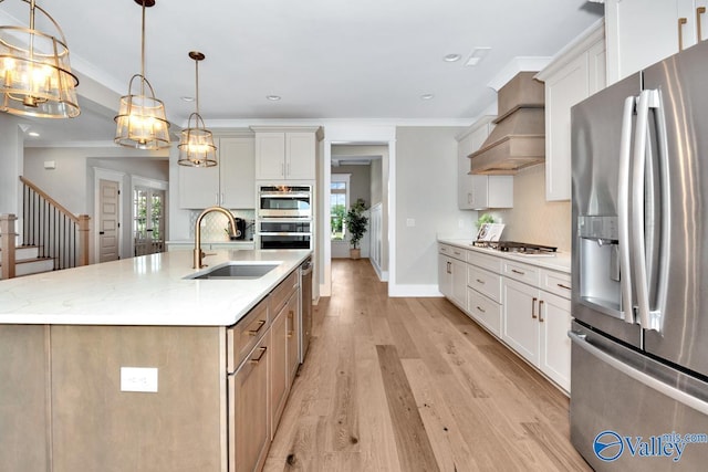 217 Idle Creek Dr, Huntsville, AL 35811 - kitchen with light wood-type flooring, premium range hood, a kitchen island with sink, stainless steel appliances, and a sink