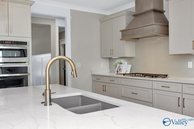 217 Idle Creek Dr, Huntsville, AL 35811 - kitchen featuring ornamental molding, light stone counters, a sink, stainless steel appliances, and custom range hood