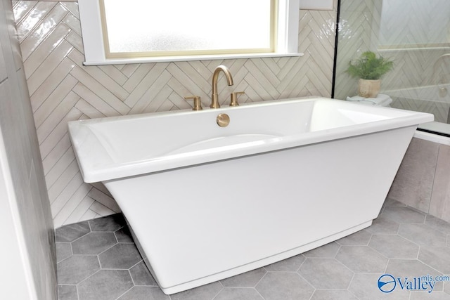 217 Idle Creek Dr, Huntsville, AL 35811 - bathroom with tile walls, a freestanding tub, and tile patterned flooring