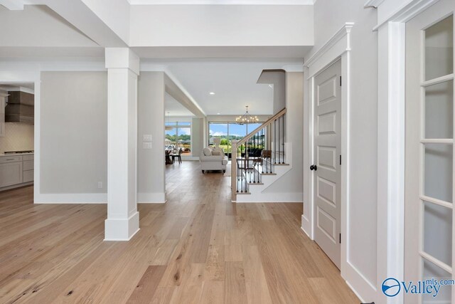 217 Idle Creek Dr, Huntsville, AL 35811 - entrance foyer with baseboards, an inviting chandelier, light wood-type flooring, decorative columns, and stairs