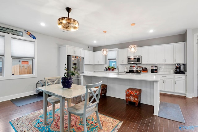 dining room with dark wood-type flooring, recessed lighting, and baseboards