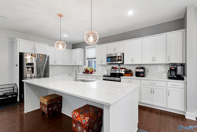 kitchen featuring white cabinets, appliances with stainless steel finishes, dark wood-style flooring, and a sink