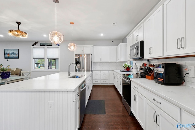 kitchen featuring white cabinets, backsplash, stainless steel appliances, and a sink