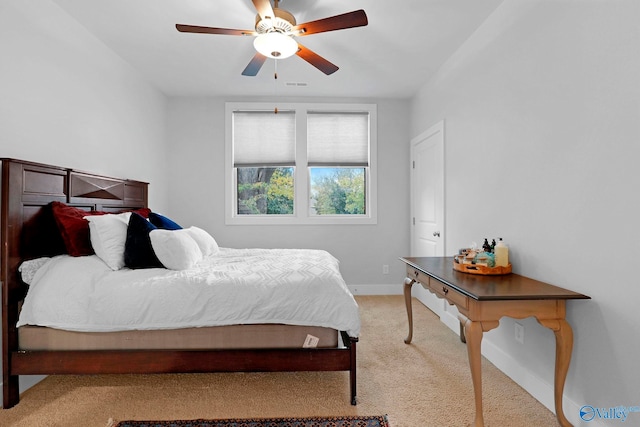 bedroom featuring baseboards, visible vents, ceiling fan, and light colored carpet