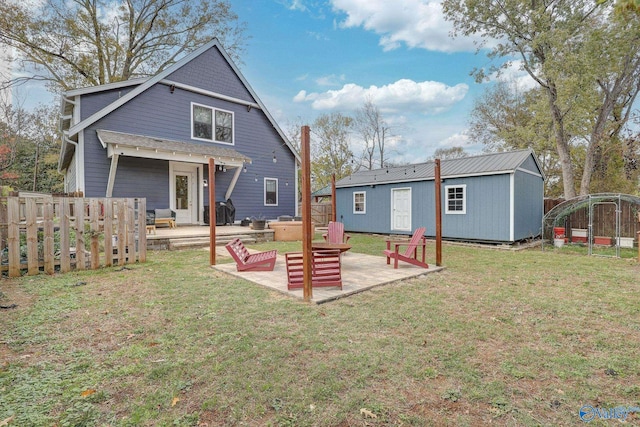 back of house with a yard, a patio area, an outdoor structure, and fence