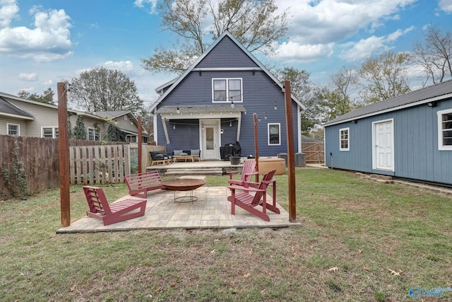 back of property featuring a patio area, a fenced backyard, a lawn, and an outdoor structure