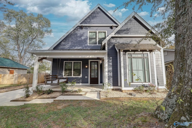 view of front of house featuring fence and a porch