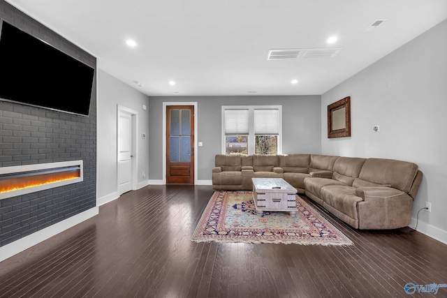 living area featuring recessed lighting, a large fireplace, baseboards, and wood finished floors