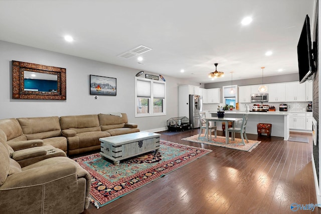 living area with dark wood-style floors, visible vents, and recessed lighting