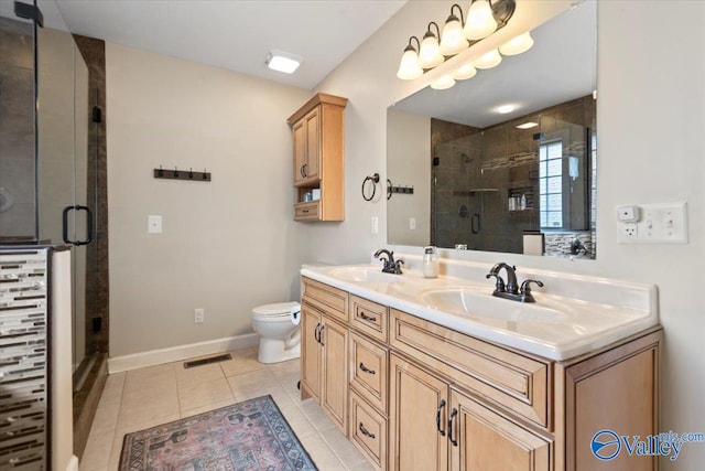 bathroom featuring tile patterned floors, toilet, vanity, and walk in shower