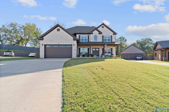 view of front of property featuring a garage, a front yard, and a porch