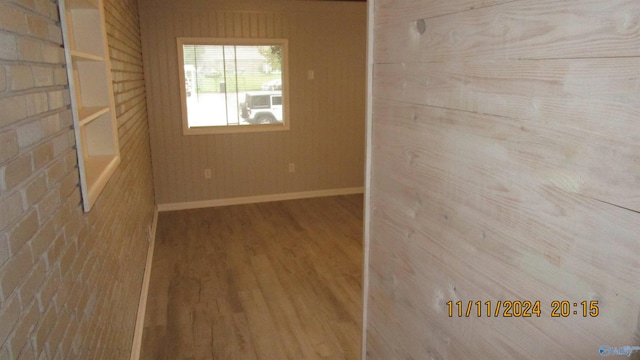 empty room with hardwood / wood-style floors and wood walls