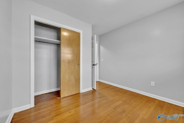 unfurnished bedroom with wood-type flooring and a closet