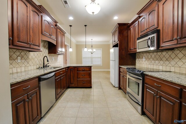 kitchen with a sink, a peninsula, stainless steel appliances, visible vents, and ornamental molding