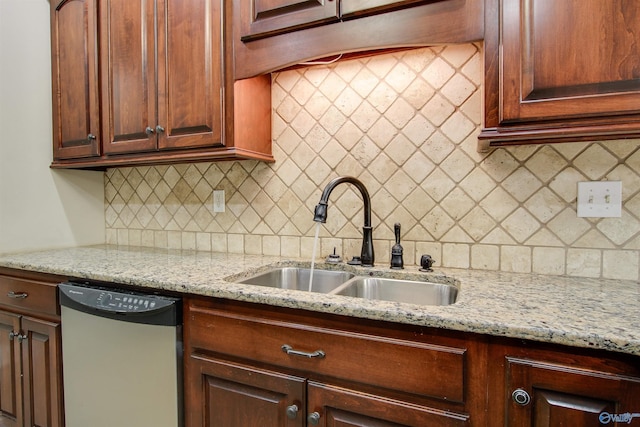 kitchen with light stone countertops, a sink, backsplash, and dishwasher
