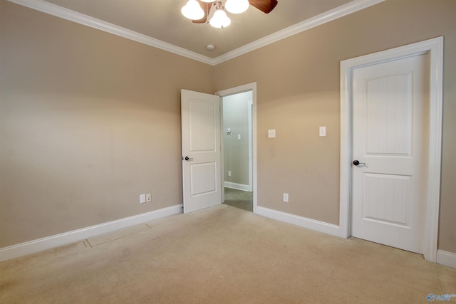 unfurnished bedroom featuring baseboards, ceiling fan, crown molding, and light colored carpet