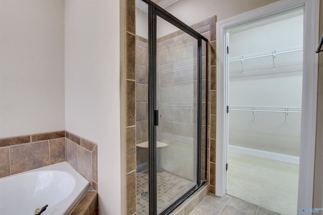 full bath featuring a walk in closet, a garden tub, and a shower stall