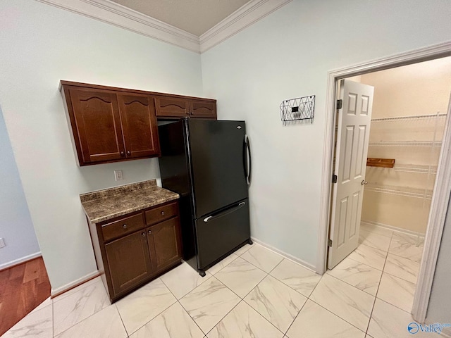 kitchen with black refrigerator, dark brown cabinetry, and crown molding