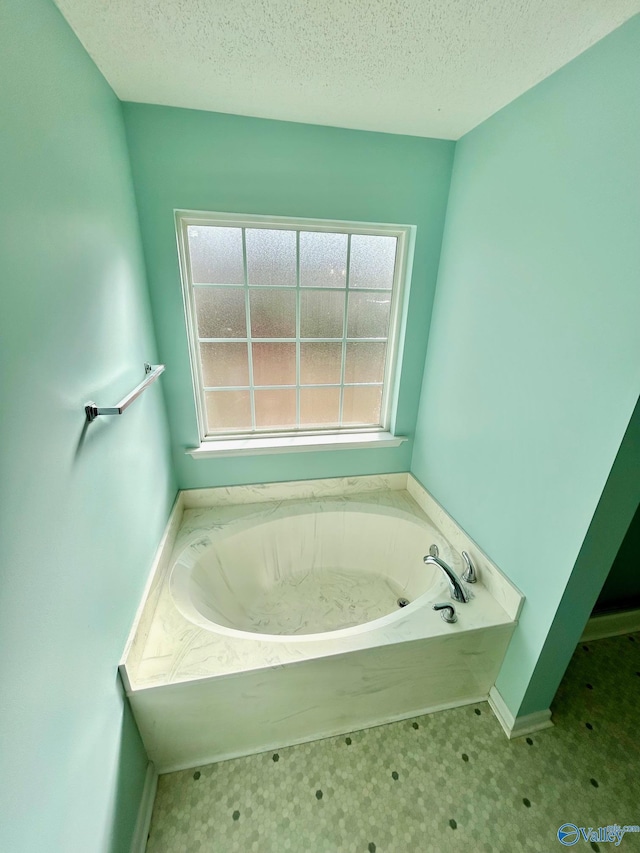 bathroom featuring a textured ceiling and a bath