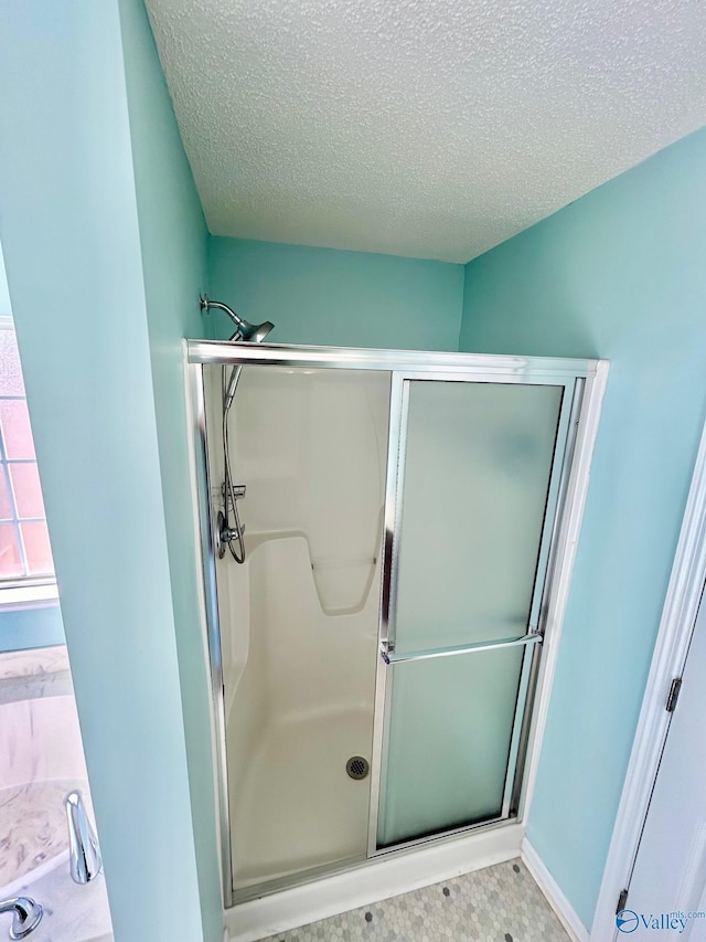 bathroom featuring a textured ceiling and an enclosed shower