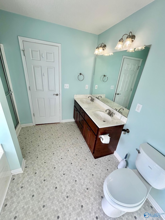 bathroom featuring vanity, toilet, and a shower with door