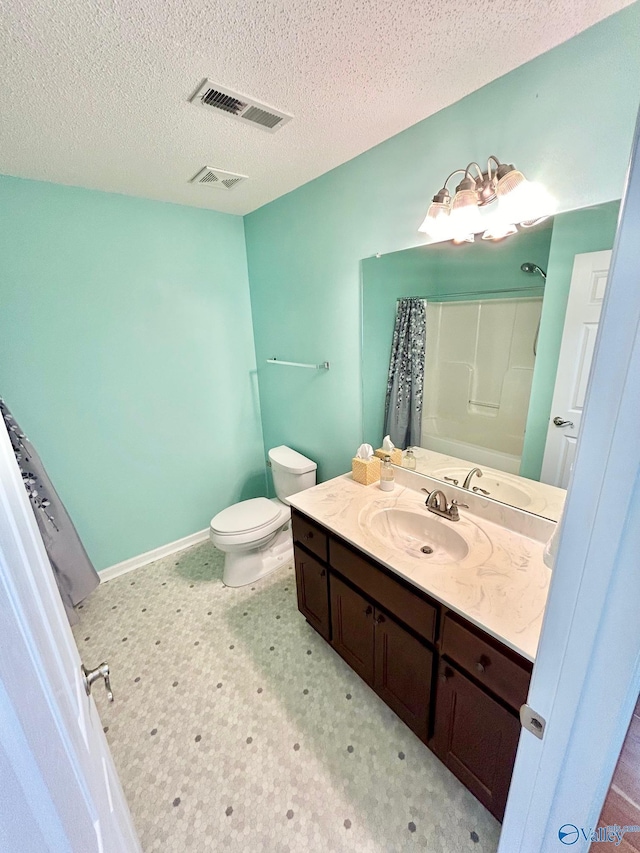 bathroom featuring a textured ceiling, vanity, and toilet