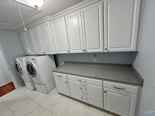 washroom featuring cabinets, a textured ceiling, and separate washer and dryer