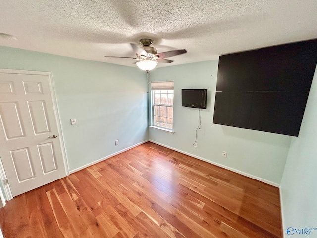 empty room with wood-type flooring, a textured ceiling, and ceiling fan